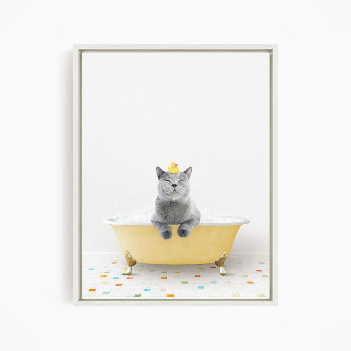 A gray cat sitting in a yellow bathtub, with a yellow rubber duck on its head, and a colorful tiled floor in the background.