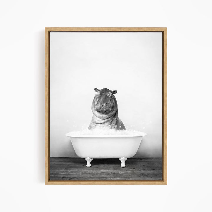 A black and white photograph of a hippopotamus sitting in a bathtub filled with water.