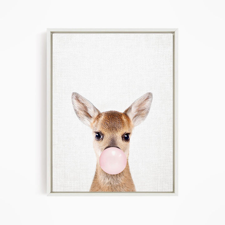 A deer with large ears blowing a pink bubblegum bubble.