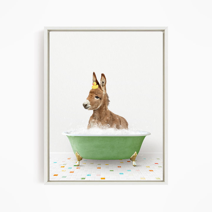 A donkey is sitting in a green bathtub filled with bubbles, with a yellow rubber duck hanging from its head.