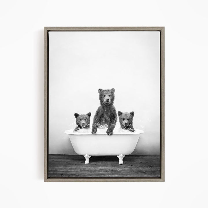 A black and white image of three bears sitting in a bathtub.