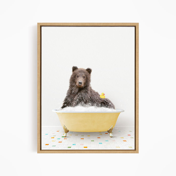 A brown bear sitting in a yellow bathtub, with a yellow rubber duck floating on the water.