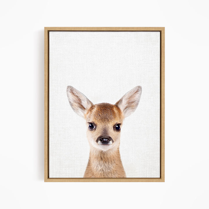 A framed print of a deer's head with large, alert eyes and a small nose, set against a plain white background.