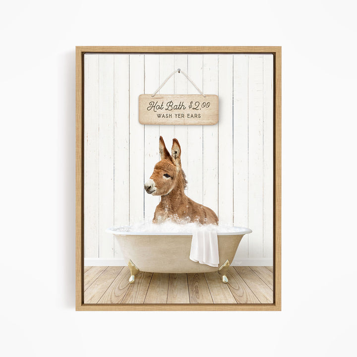 A donkey is sitting in a bathtub filled with water, with a sign above it that reads "Hot Bath $2.00 WASH YOUR EARS".