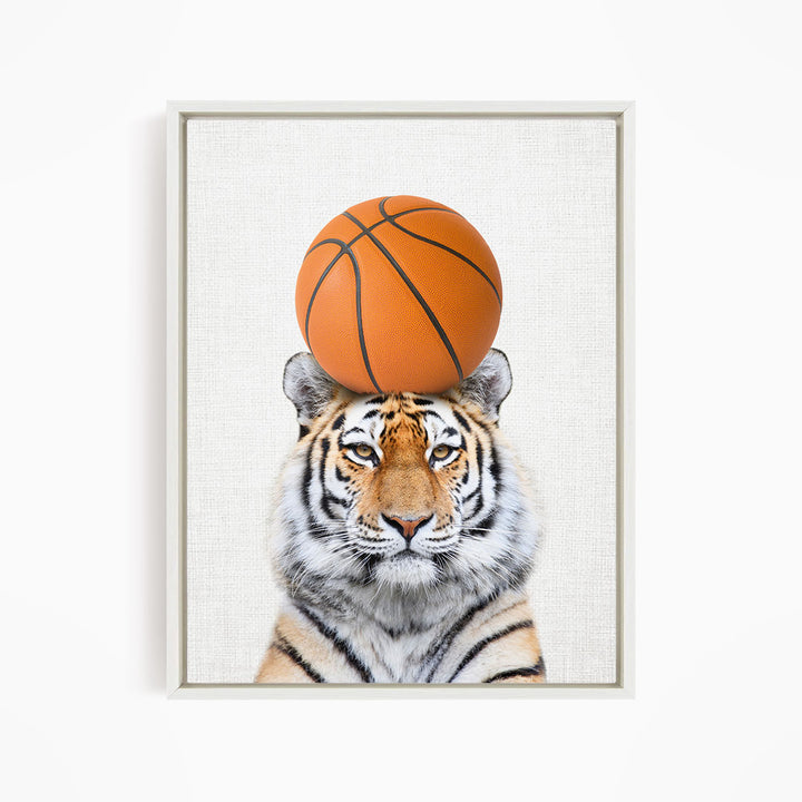 A tiger is sitting on a basketball, with the basketball positioned on its head.