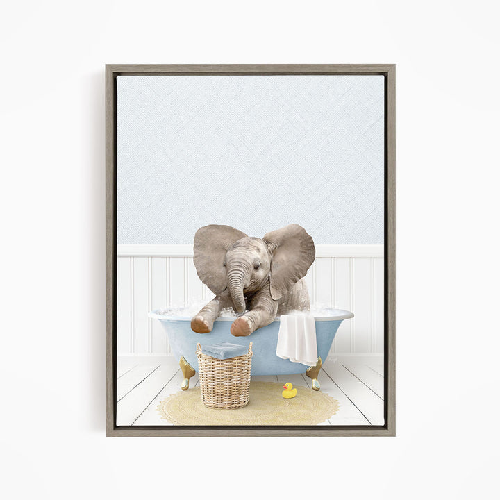 A baby elephant sitting in a bathtub filled with water, surrounded by a basket of toys and a yellow rubber ducky.