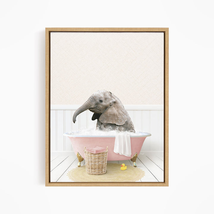 A gray elephant is sitting in a pink bathtub filled with water, surrounded by a yellow rubber duck and a basket.