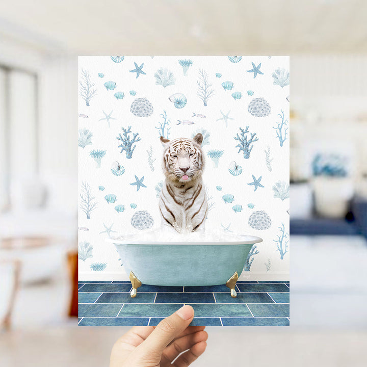 A hand is holding up a framed image of a tiger sitting in a bathtub filled with bubbles, surrounded by a pattern of seashells, starfish, and other marine life.