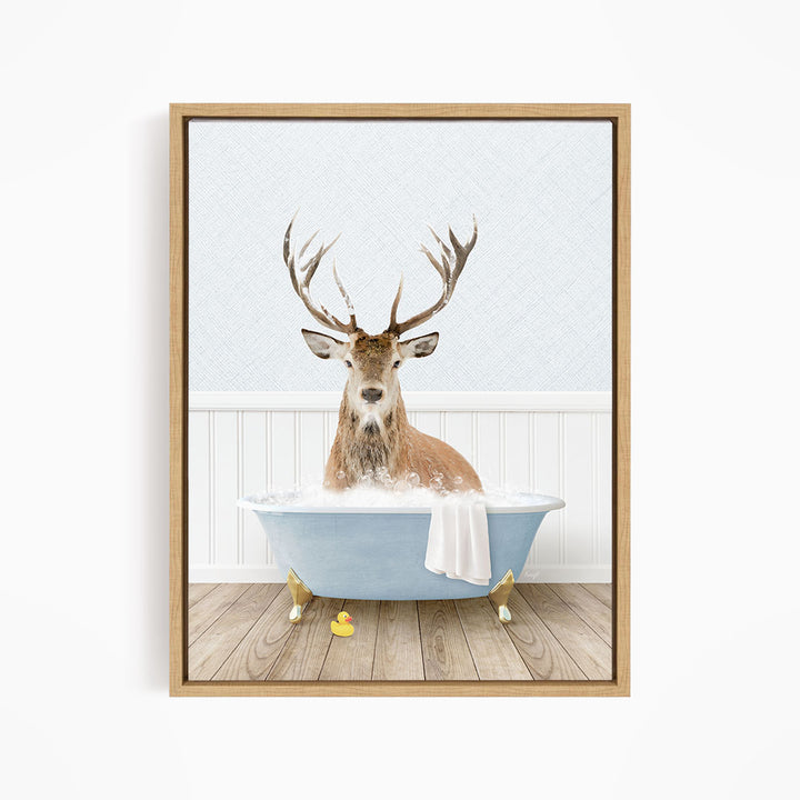 A deer with large antlers is sitting in a blue bathtub filled with water, surrounded by rubber ducks.