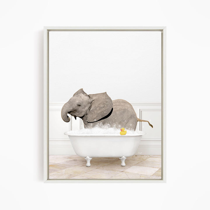 A gray elephant is standing in a white bathtub filled with water, with a yellow rubber duck floating on the water.