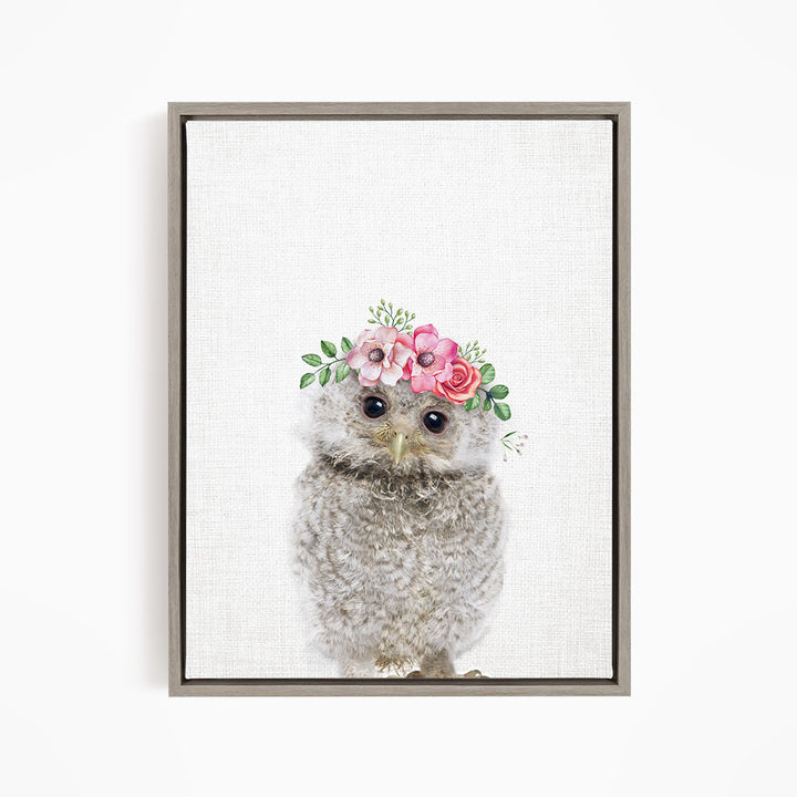 A cute baby owl wearing a flower crown on its head.