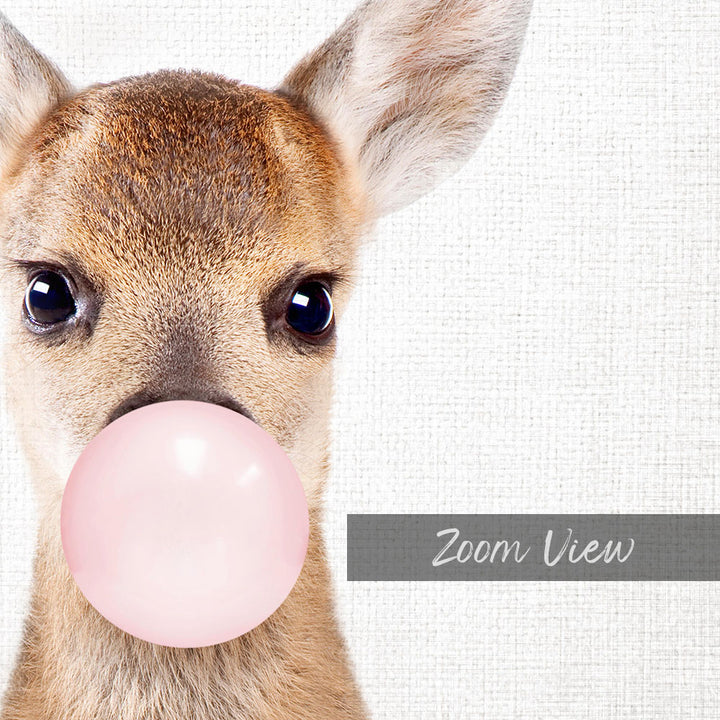A deer with a pink bubble gum bubble in its mouth, looking directly at the camera.