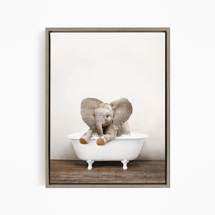 A baby elephant sitting in a white bathtub, with its trunk in the water.
