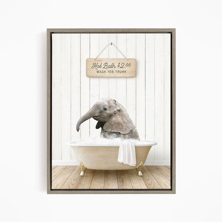A gray elephant is sitting in a white bathtub, with a wooden sign above it that reads "Hot Bath $2.00 WASH YER TRUNK".