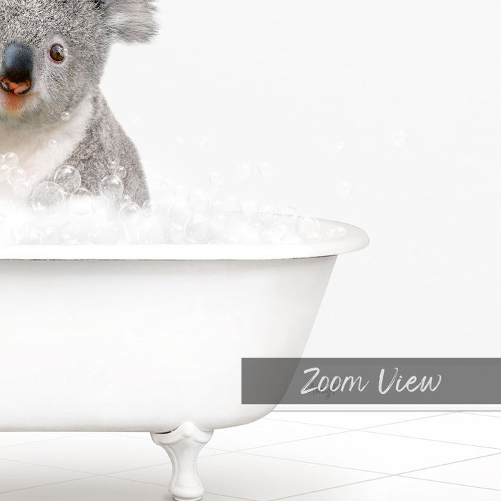 A koala sitting in a white bathtub filled with bubbles, as if enjoying a bath.