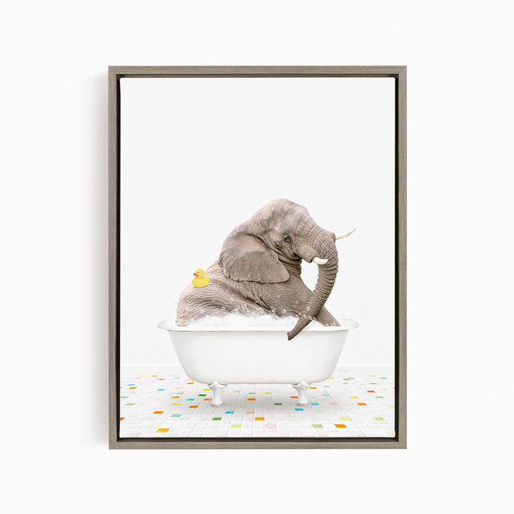 A gray elephant is sitting in a white bathtub, with a yellow rubber duck floating on its back.