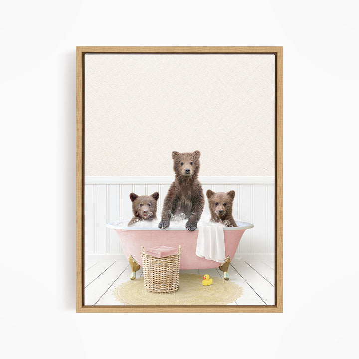 A framed image depicting three bears sitting in a pink bathtub, with a yellow rubber duck floating in the water.