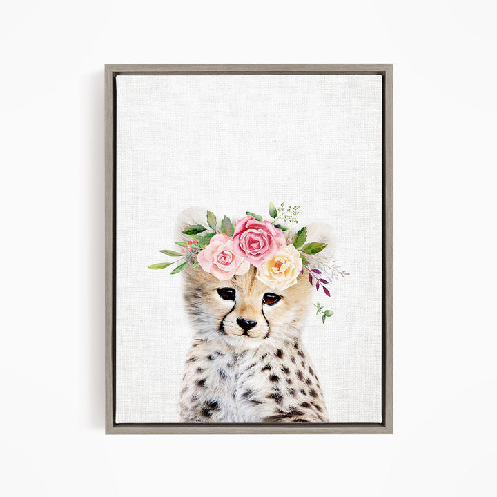 A cheetah wearing a floral crown of pink and yellow flowers.