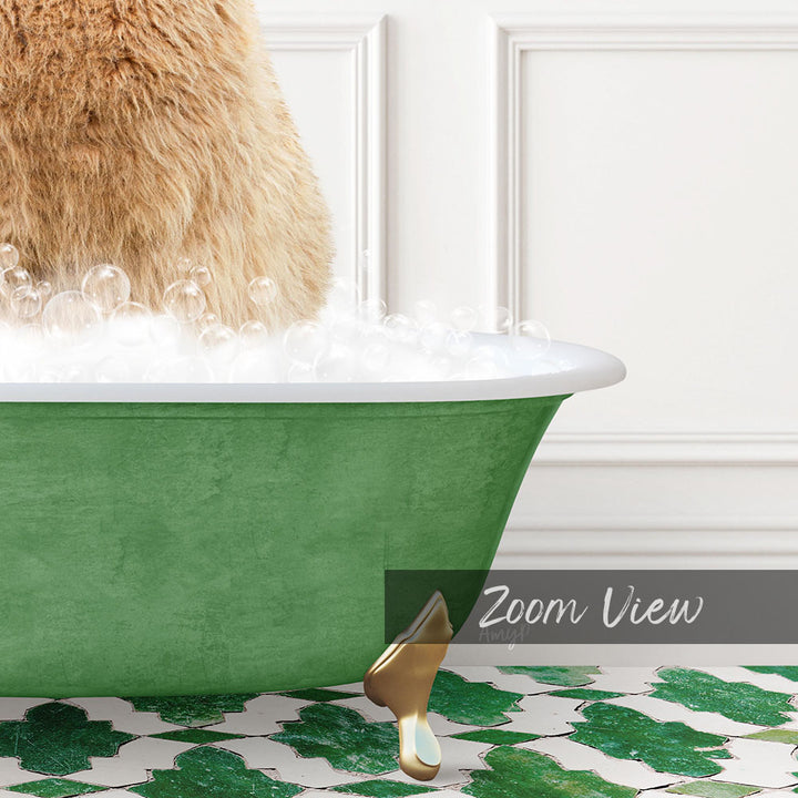 A fluffy brown cat is sitting in a green bathtub filled with bubbles, with a gold claw-like object resting on the edge of the tub.