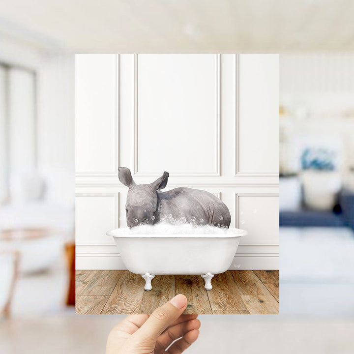 A rhinoceros is sitting in a bathtub filled with water, creating a whimsical and playful scene.