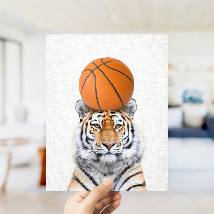 A tiger is standing on a basketball, with the ball balanced on its head.