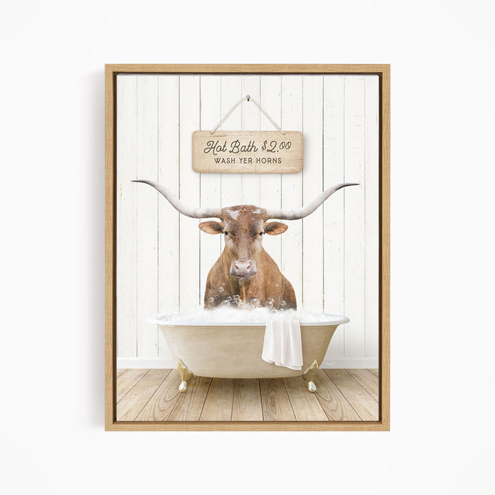A framed image depicting a brown cow with large horns sitting in a bathtub, with a sign above the tub stating "Hot Bath $2.00 WASH YOUR HORSES".