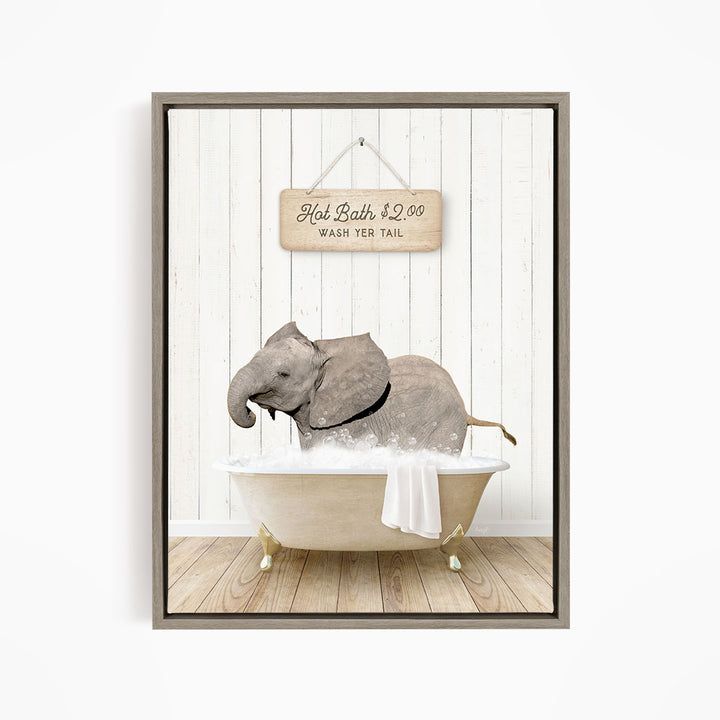 A framed image depicting a gray elephant sitting in a bathtub, with a sign above it that reads "Hot Bath $2.00 WASH YER TAIL".
