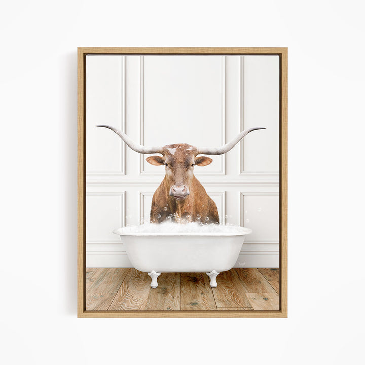 A brown cow with large horns is sitting in a white bathtub, surrounded by a white wall and wooden floor.
