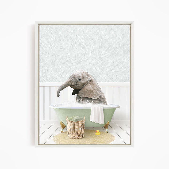 A baby elephant sitting in a green bathtub filled with water, surrounded by a yellow rubber duck and a wicker basket.