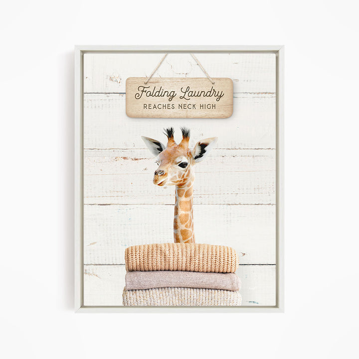 A giraffe standing on a pile of folded clothes, with a sign above that says "Folding Laundry Reaches Neck High".