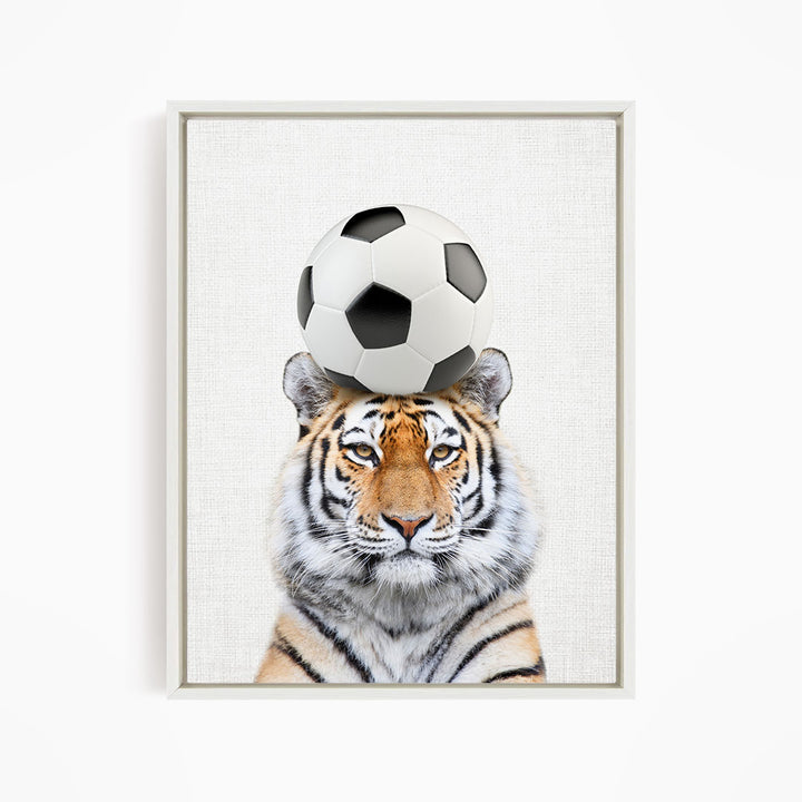 A tiger is balancing a soccer ball on its head, creating a playful and amusing scene.