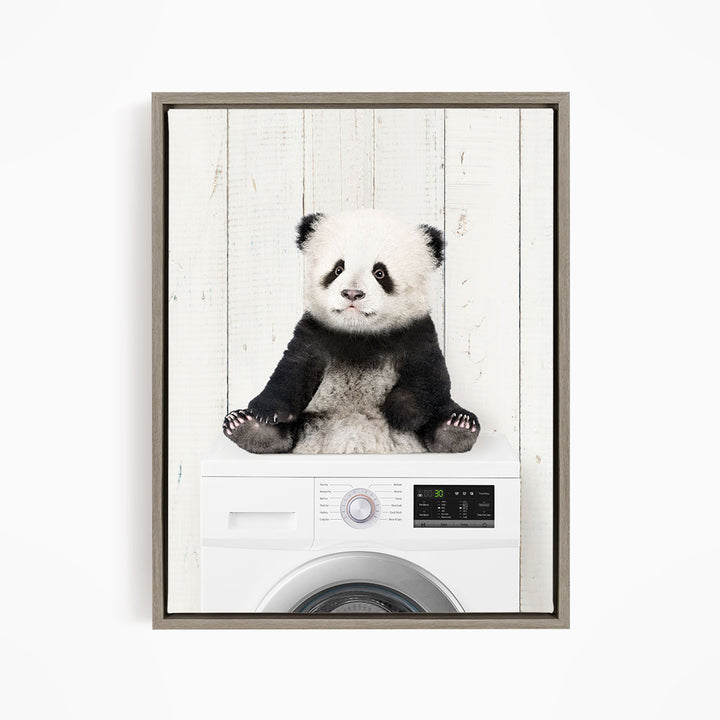 A panda bear sitting on top of a washing machine.
