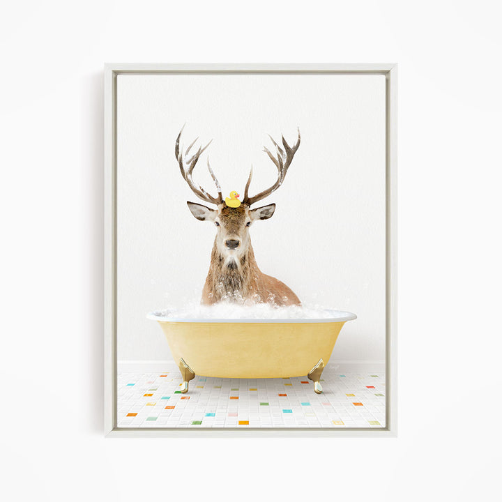 A deer with antlers is sitting in a yellow bathtub filled with bubbles, with a rubber duck floating on its head.