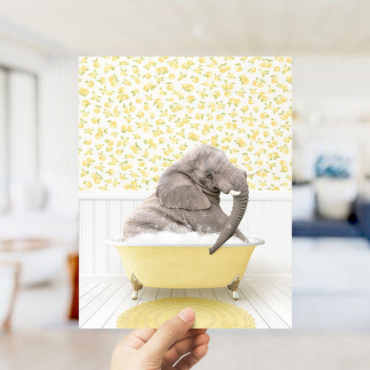 A gray elephant sitting in a yellow bathtub filled with bubbles, surrounded by a yellow and white floral patterned wall.
