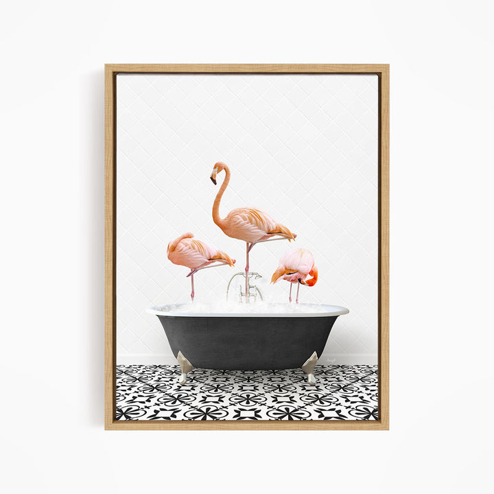 A framed image depicting three pink flamingos standing in a bathtub filled with water, surrounded by a black and white patterned tile floor.