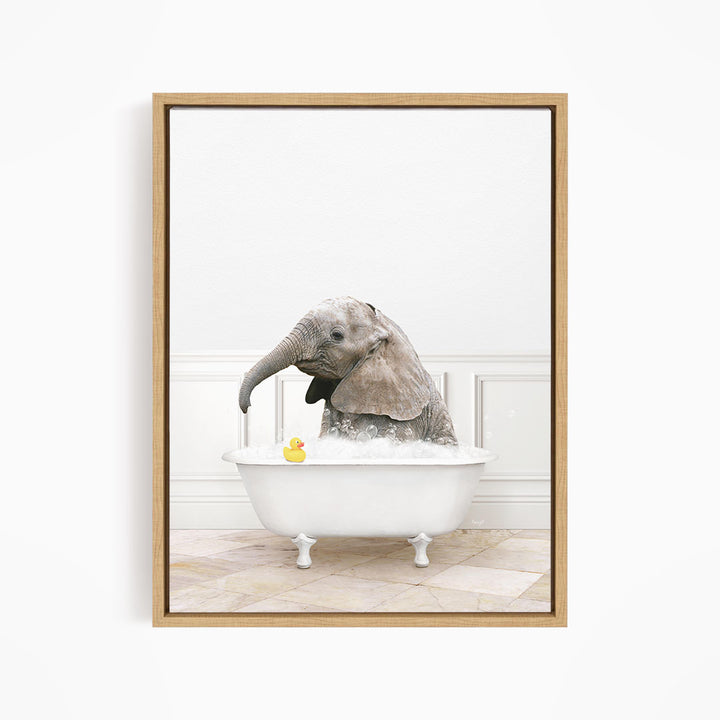 A gray elephant is sitting in a white bathtub filled with water, with a yellow rubber duck floating nearby.