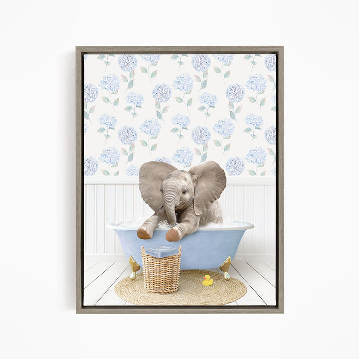 A gray elephant is sitting in a blue bathtub filled with water, surrounded by a wicker basket and yellow rubber ducks.