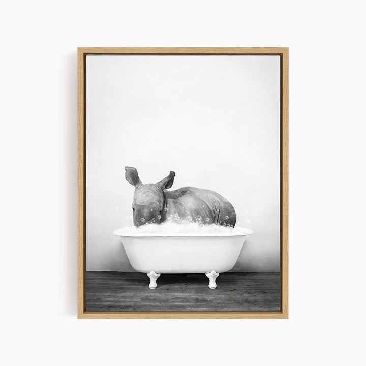 A rhinoceros is sitting in a bathtub filled with water, creating a whimsical and playful scene.