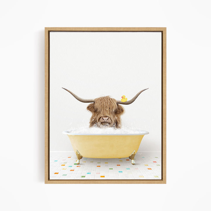 A brown cow with long horns is sitting in a yellow bathtub filled with bubbles, with a rubber duck floating on the water.