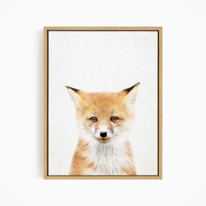 A framed print of a fox's face, with its distinctive features such as its large eyes, pointed ears, and reddish-brown fur prominently displayed.