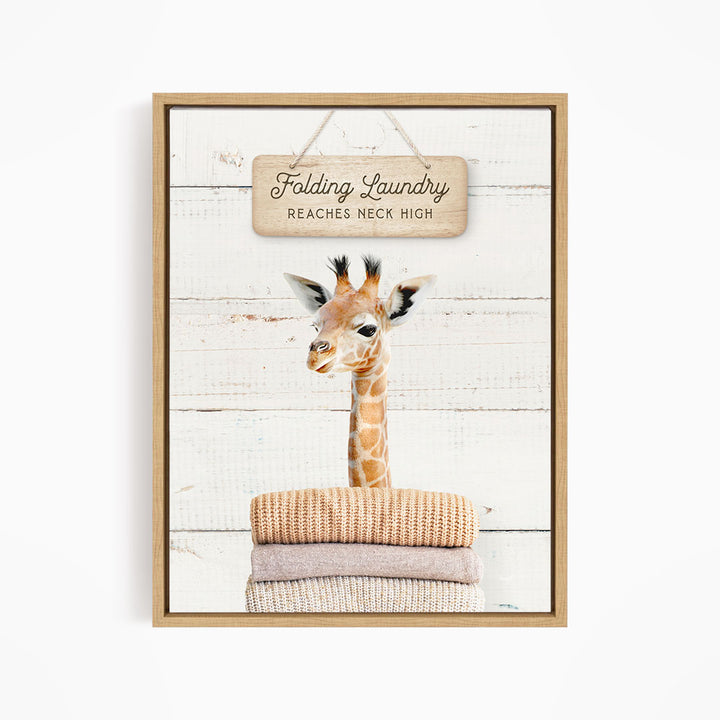 A giraffe standing on a stack of folded clothes, with a sign above that says "Folding Laundry Reaches Neck High".