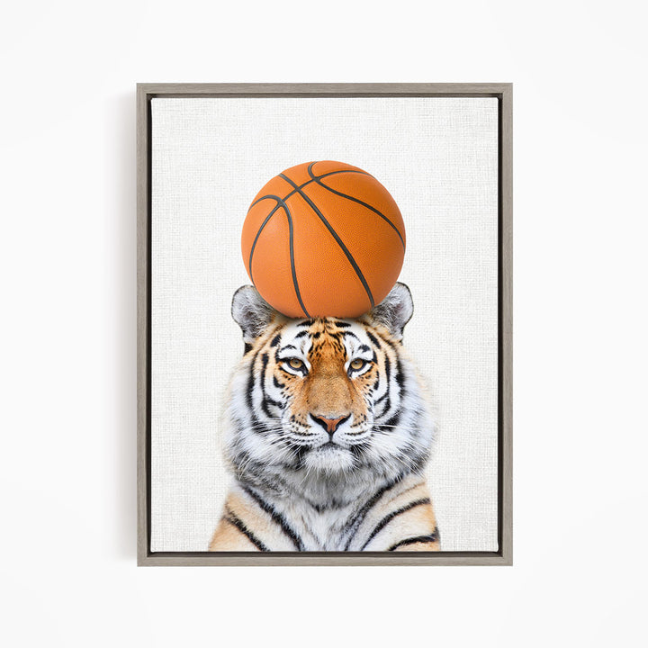 A tiger is sitting on a basketball, with the basketball positioned on top of its head.