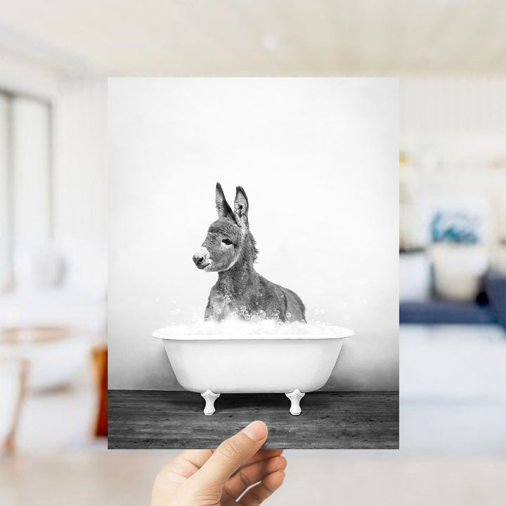 A donkey sitting in a bathtub filled with water, as if taking a bath.