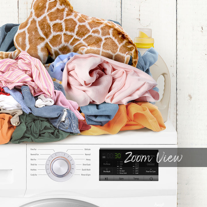 A laundry machine with various settings and a pile of clothes on top of it.