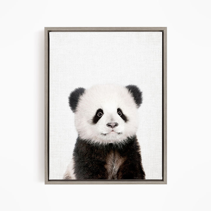 A panda bear with its distinctive black and white fur is the focus of the image, which is a framed print of the panda bear.