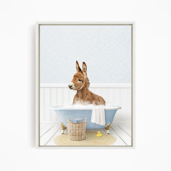 A donkey is sitting in a blue bathtub filled with water, surrounded by a yellow rubber duck and a basket.