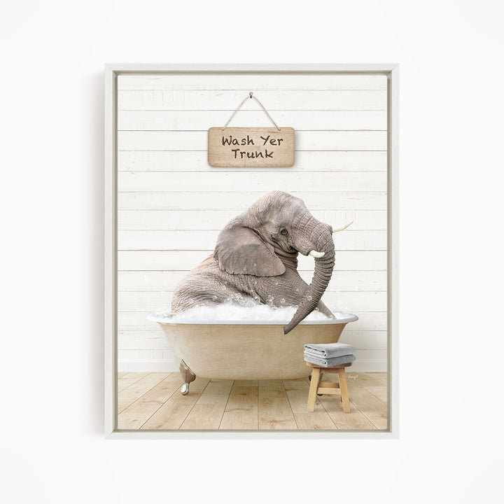 A gray elephant sitting in a bathtub, with a wooden sign above it that says "Wash Yer Trunk".