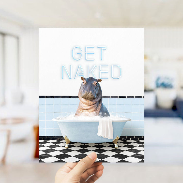 A hand holding a printed image of a hippopotamus sitting in a bathtub, with the text "GET NAKED" displayed above it.