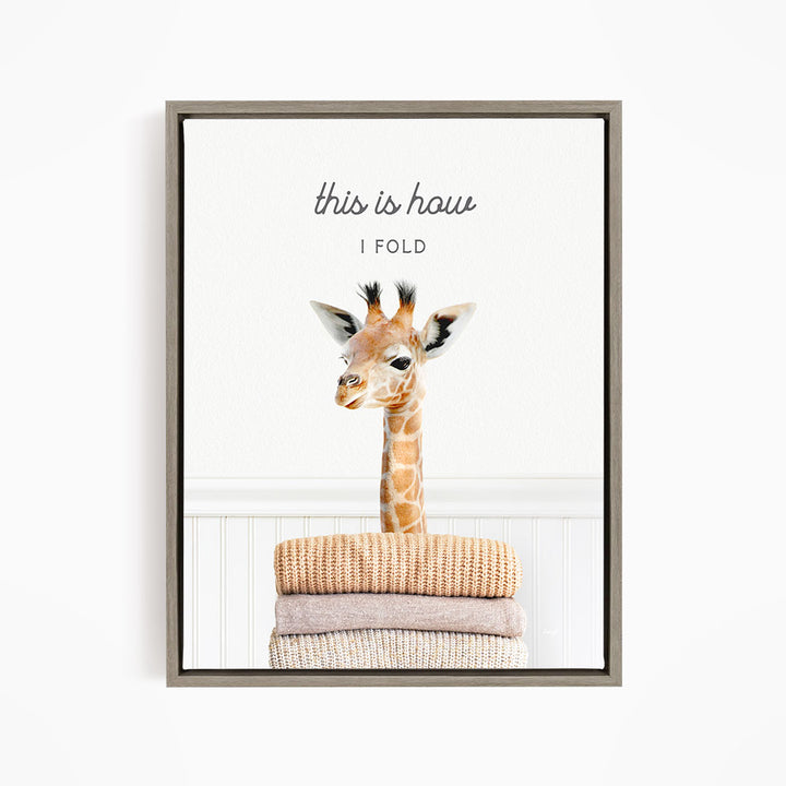 A giraffe standing on a stack of folded blankets, with the text "this is how I fold" written above the image.