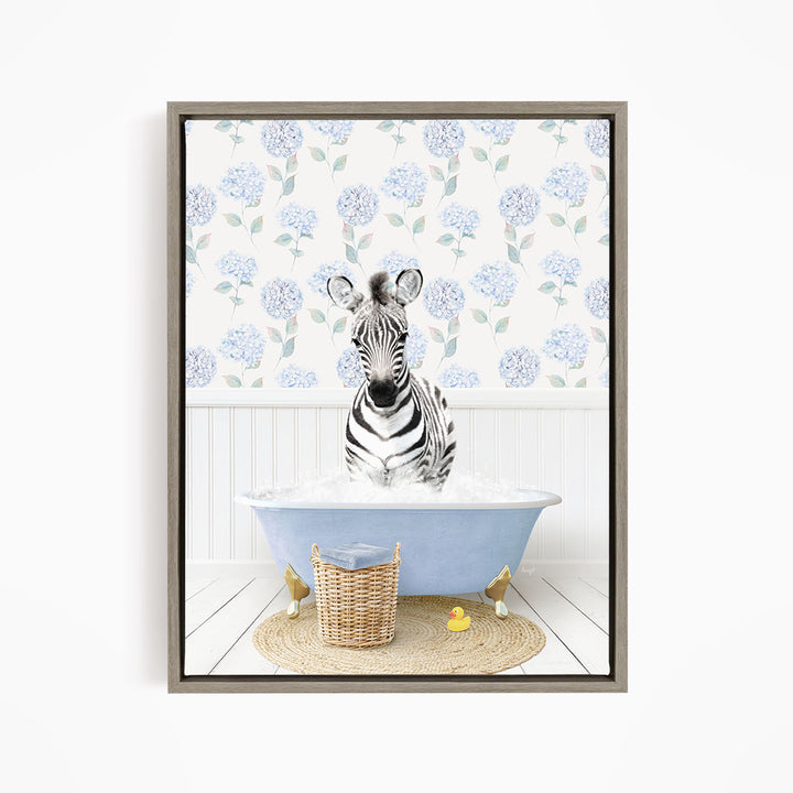 A zebra sitting in a blue bathtub filled with water, surrounded by a wicker basket and yellow rubber ducks.